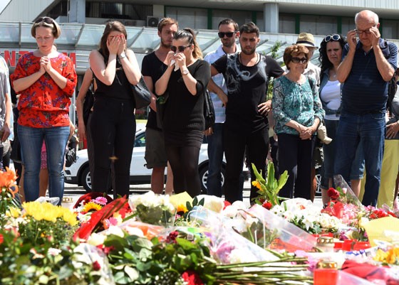 Familiares lamentam a morte de vítimas de atirador em Munique, em meio a um memorial com velas e flores (Foto: CHRISTOF STACHE / AFP) Familiares lamentam a morte de vítimas de atirador em Munique, em meio a um memorial com velas e flores (Foto: CHRISTOF STACHE / AFP)