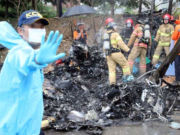 Bombeiros inspecionam os destroços de um helicóptero que caiu em Gwangju. (Foto: Park Cheol-hong / Yonhap / Via Reuters)