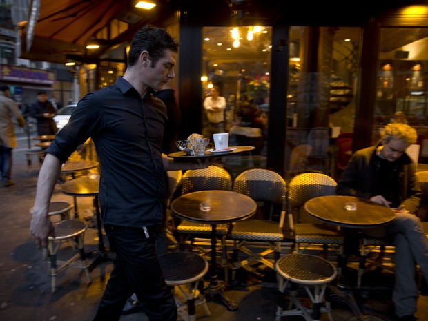 Garçom passa com bandeja no bar La Bonne Bière, alvo dos atentados em Paris que reabriu nesta sexta-feira (4) (Foto: KENZO TRIBOUILLARD / AFP) Garçom passa com bandeja no bar La Bonne Bière, alvo dos atentados em Paris que reabriu nesta sexta-feira (4) (Foto: KENZO TRIBOUILLARD / AFP)
