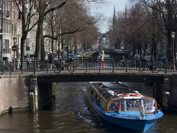 Barco passa por um dos canais de Amsterdã (Foto: Peter Dejong/AP Photo)