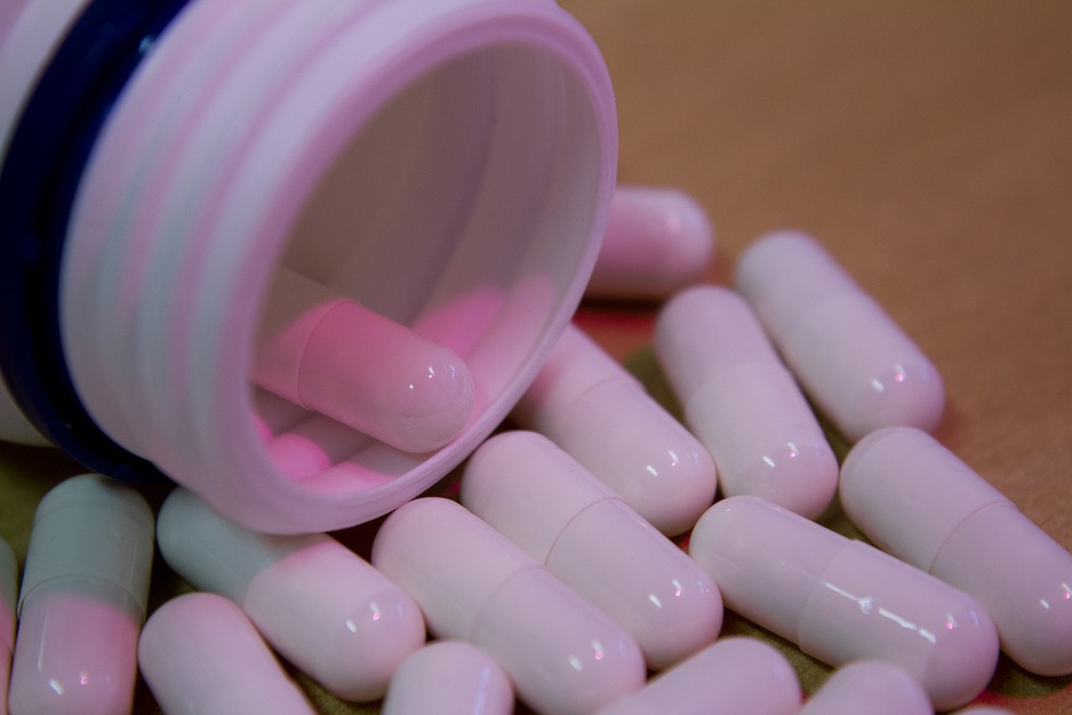 Cápsulas de remédios espalhadas sobre mesa (Foto: Marcos Santos/USP Imagens)