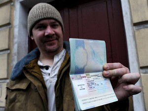 O britânico Anthony Perrett, primeiro militante do Greenpeace a receber visto russo, mostra seu passaporte com o visto russo.  (Foto: AFP Photo/Olga Maltseva)