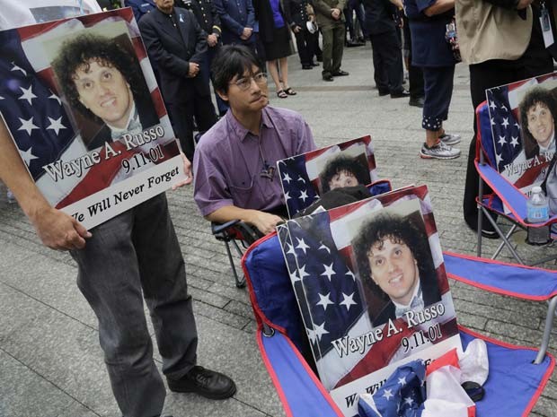 Lito Deleon segura cartaz com foto de seu amigo Wayne Russo, vítima do atentado, durante cerimônia nesta quinta-feira (11) em Nova York (Foto: AP Photo/Mark Lennihan, Pool)