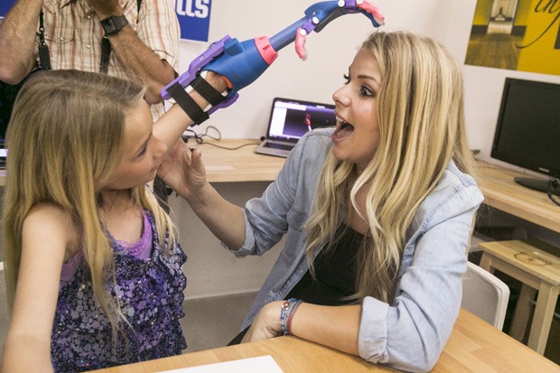 Faith mostra para sua mãe, Nicole, sua nova mão feita em impressora 3D (Foto: AP Photo/Damian Dovarganes ) Faith mostra para sua mãe, Nicole, sua nova mão feita em impressora 3D (Foto: AP Photo/Damian Dovarganes )