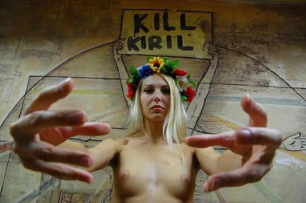 Na véspera, o grupo já havia antecipado que protestaria contra o patriarca em uma fotografia divulgada mostrando uma das feministas com a mesma frase ('Matem Kirill') ao fundo e aparentemente encenando um gesto de estrangulamento. (Foto: AFP/Divulgação/Femen)