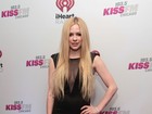 Avril Lavigne deixa estilo roqueiro de lado e usa vestido sexy
