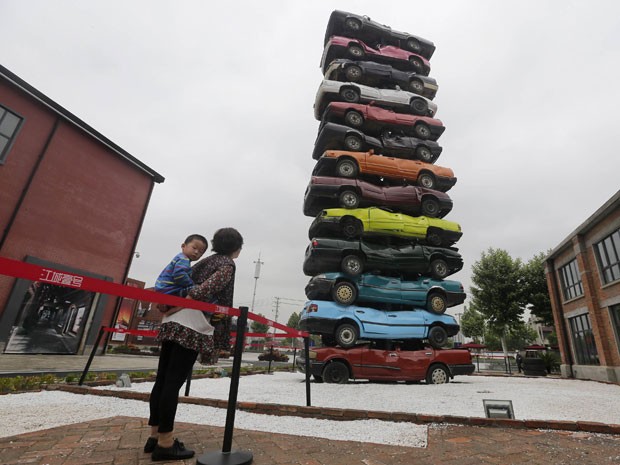 Pessoam olham escultura de carros na China (Foto: REUTERS/Stringer)