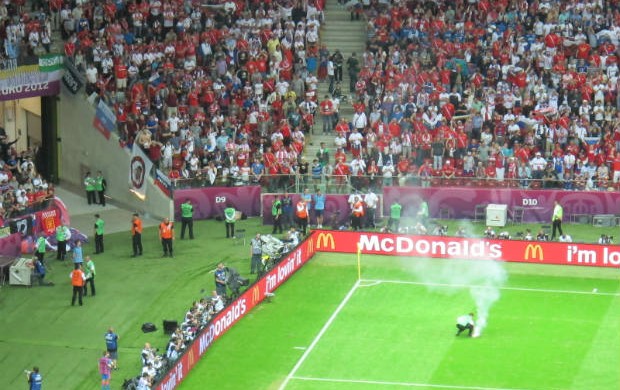 Funcionário retira um rojão atirado pela torcida russa (Foto: Marcos Felipe / GLOBOESPORTE.COM)