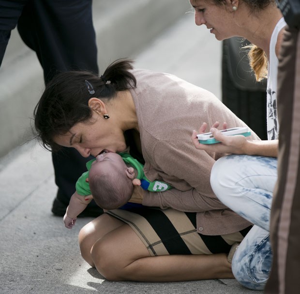 Pamela Rauseo tenta fazer seu sobrinho de 5 meses voltar a respirar no meio de rodovia nos EUA (Foto: The Miami Herald, Al Diaz/AP)