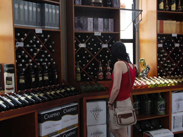 Cliente escolhe vinhos em adega de Andradas. (Foto: Jéssica Balbino / G1)
