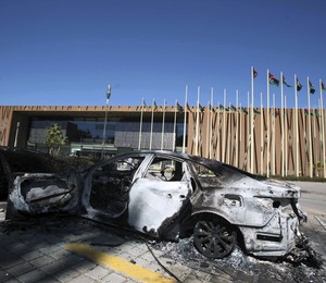 Carro queimado em frente ao prédio do Parlamento na Líbia, destruído em fevereiro em invasão de grupos armados irritados com a extensão de mandato do primeiro ministro. Desde então, o Parlamento se reúne em um hotel (Foto: EFE/Sabri Elmhedwi)