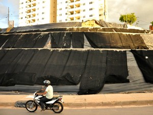 Morro perto de viaduto em Cuiabá atualmente está coberto por lonas enquanto aguarda retomada das obras. (Foto: André Souza / G1)