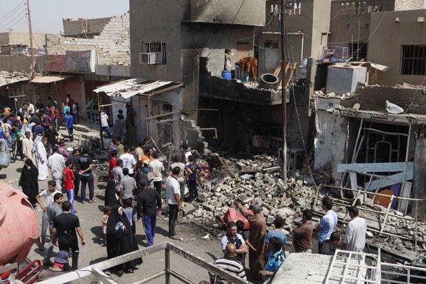 Iaquianos observam cena de explosão em Madain (Foto: AP)