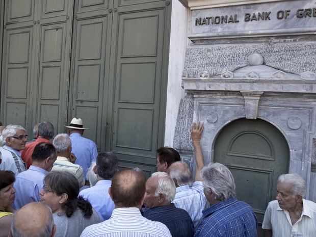 Aposentados tentam sacar seu benefício após bloqueio bancário anunciado pelo governo para evitar a quebra dos bancos (Foto: Petros Giannakouris / AP) Aposentados tentam sacar seu benefício após bloqueio bancário anunciado pelo governo para evitar a quebra dos bancos (Foto: Petros Giannakouris / AP)