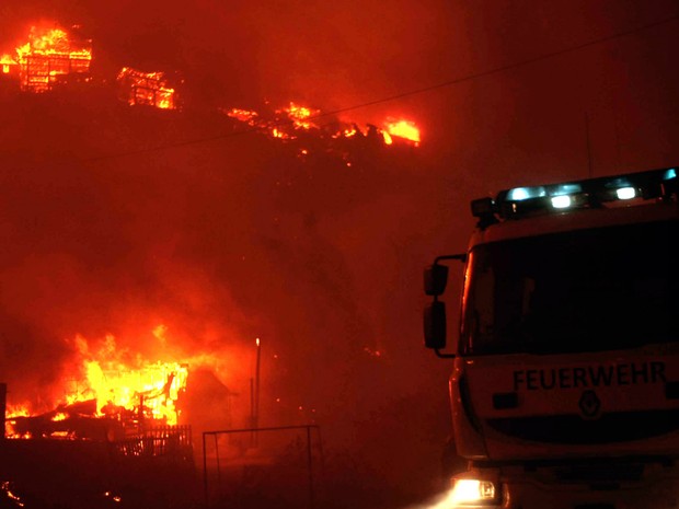 Equipes dos bombeiros trabalham no combate ao fogo que atinge a região de Valparaíso no Chile. (Foto: Felipe Gamboa/AFP)