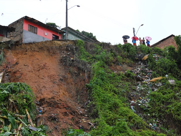 Moradores observam o deslizamento causado pela chuva. (Foto: Jonathan Lins/G1)