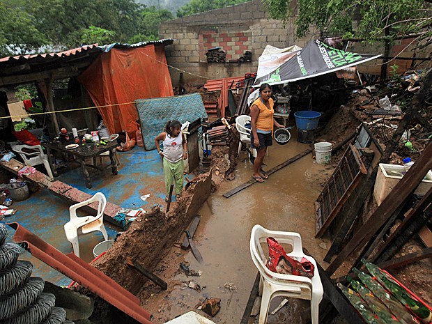 Família Campos em meio ao que restou da casa deles após chuvas provocadas pelo furacão Raymond atingirem uma comunidade perto de Acapulco, no Mexico, nesta terça-feira (22). (Foto: Marco Ugarte/AP)