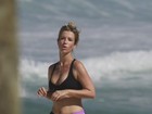 Juliana Didone corre na areia da praia usando decote e barriga de fora