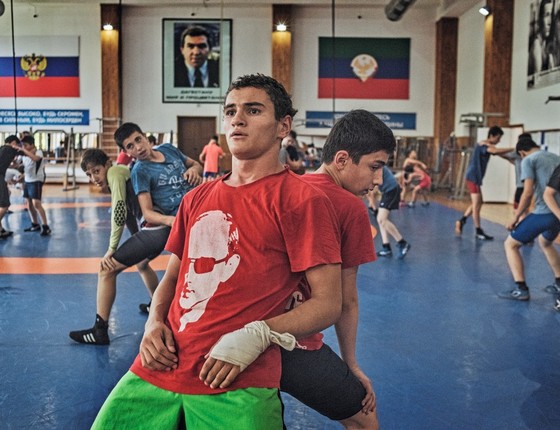 Garotos treinam luta grecoromana na escola Makhachkala,no Daguestão, uma fábrica de campeões. Além de lutar, eles recebem educação moral. A camiseta com o rosto de Putin é comum entre os jovens (Foto: Yuri Kozyrev / NOOR)