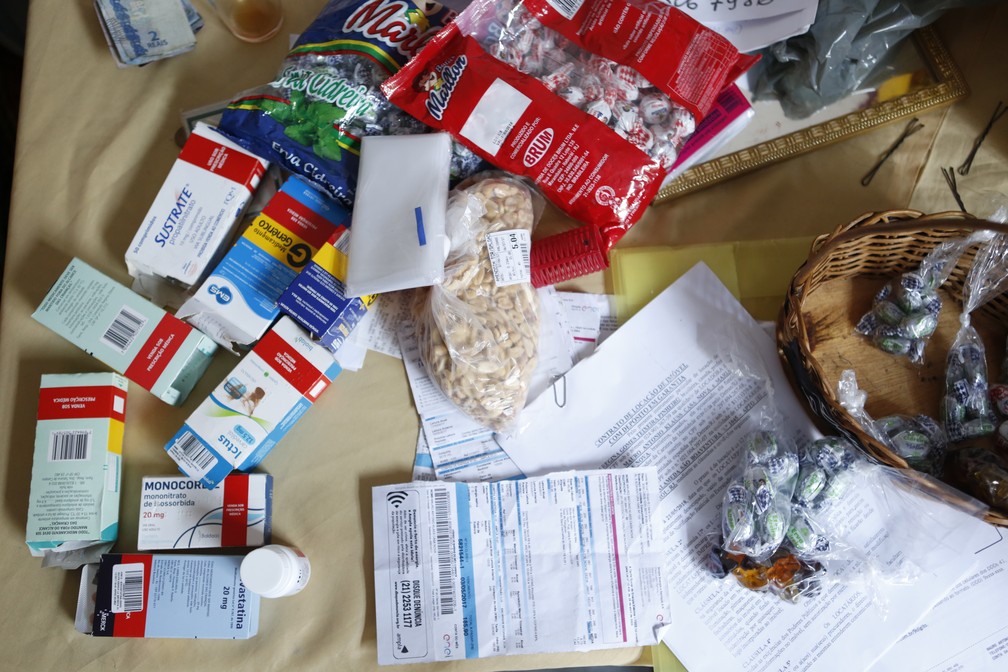 Mesa de aposentada reúne remédios, contas atrasadas e balas para vender (Foto: Marcos Serra Lima/ G1)