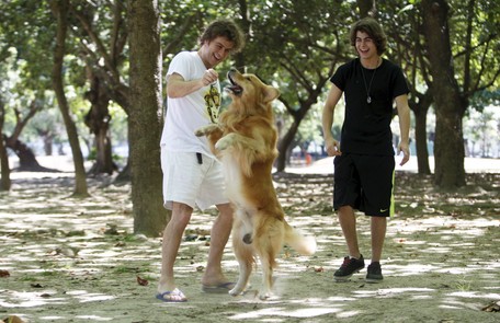 Pai e filho brincam com Simba, cachorro da família Gustavo Stephan