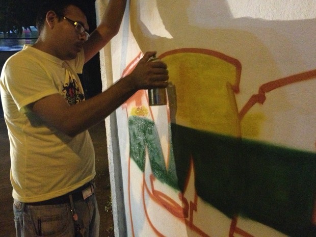 Artista plástico Sebastião Oliveira Filho grafitando no muro de escola, no centro de Macapá (Foto: Graziela Miranda/G1)