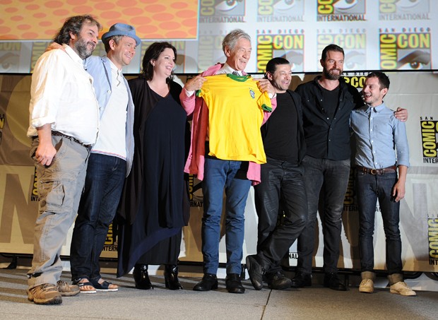 Elenco do filme posa para foto, enquanto Elijah Wood fala com os participantes do painel. Ian McKellen faz uma homenagem ao Brasil (Foto: Jordan Strauss/Invision/AP)