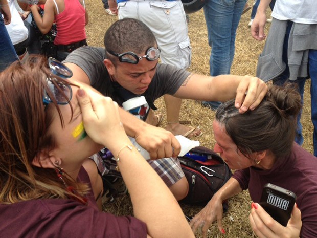 Jornalistas lavam olhos após serem atingidos com spray de pimenta (Foto: Fabiano Costa / G1)