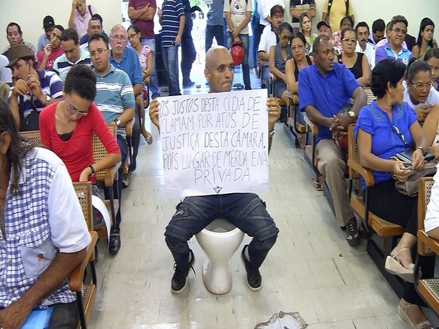 Manifestante senta em privada no plenário da Câmara de Juazeiro do Norte. (Foto: TV Verdes Mares/Reprodução)