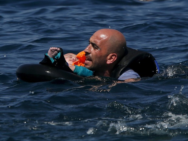 Sírio segura seu bebê após barco em que viajava naufragar a poucos metros de ilha grega (Foto: Reuters/Alkis Konstantinidis)