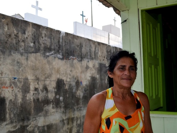 Carmelina Rodrigues vive há 15 ao lado do cemitério de Cruzeiro do Sul (Foto: Vanísia Nery/G1)