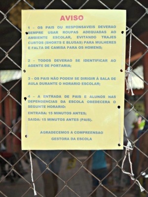 Na grade do portão, escola fixou lista de roupas proibidas (Foto: Caio Fulgêncio/G1)
