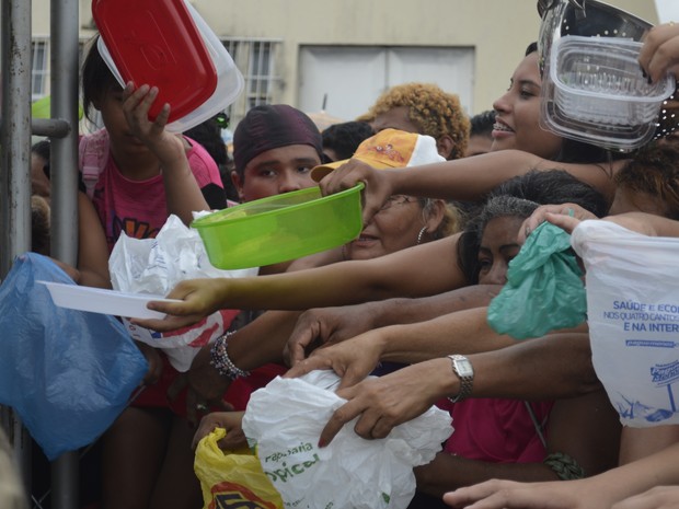 Pessoas levaram vários recipientes para levar um pedaço do bolo (Foto: Abinoan Santiago/G1)