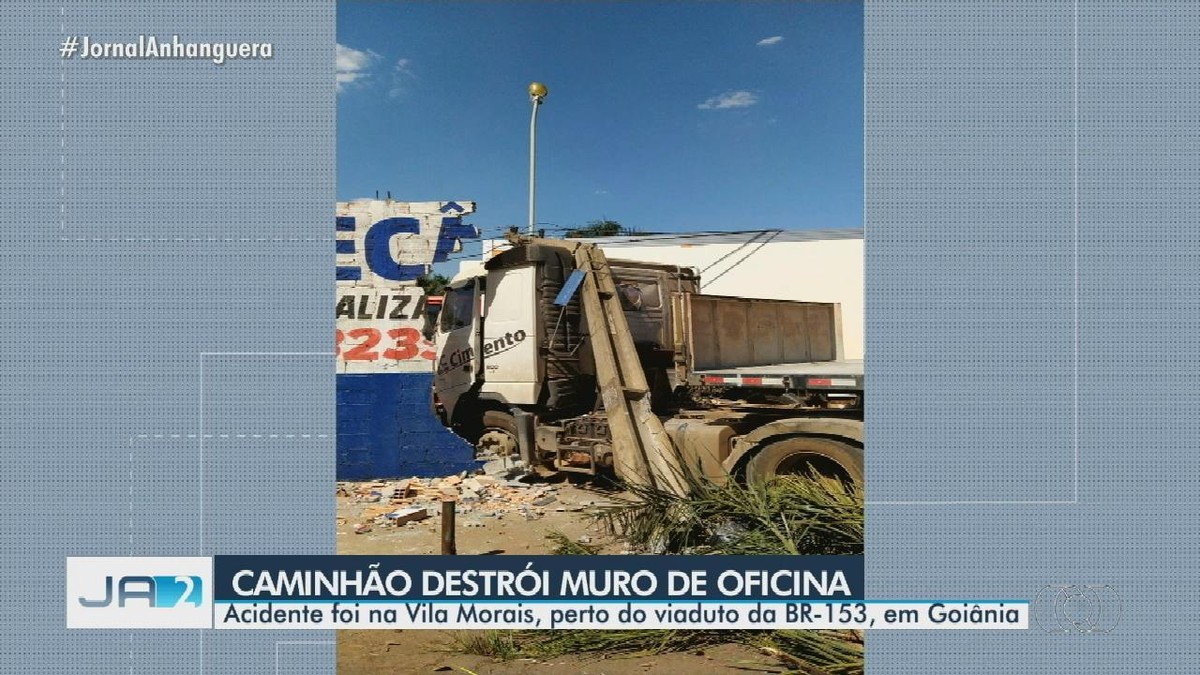 Caminhão derruba poste e vai parar dentro de oficina após batida em