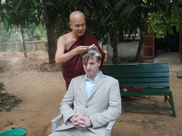 O professor de história britânico Rupert Arrowsmith tem seu cabelo raspado por um monge de Mianmar (Foto: Soe Than Win/AFP)