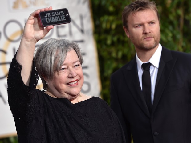 Atriz Kathy Bates levanta placa 'Je suis Charlie', lembrando o massacre ocorrido na quarta-feira em Paris. (Foto: John Shearer/Invision/AP)