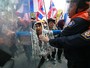 Agentes de segurança da Tailândia tentam conter manifestantes durante protesto  contra o governo em frente ao Departamento de Investigação Especial em Bangcoc. Na semana passada,  o órgão decidiu congelar as contas bancárias dos líderes dos protestos