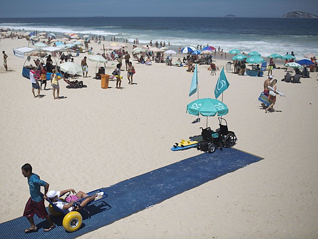 Fisioterapeuta Luis Phelipe Nobre empurra cadeira de rodas adaptada no Leblon (Foto: Felipe Dana/AP)