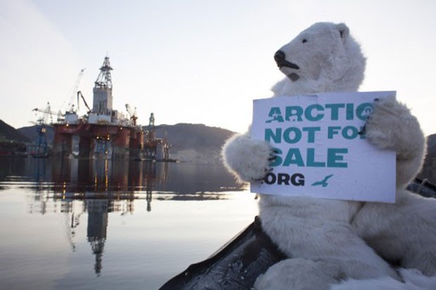 Manifestante vestido de urso segura placa com dizeres (em inglês) "Ártico não está à venda" (Foto: Nick Cobbing/Greenpeace/AFP)