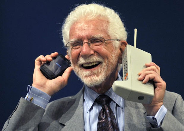 Martin Cooper, em imagem de 2009, mostra o primeiro celular (à direita), que completa 40 anos, e o compara com um modelo mais atual (Foto: Eloy Alonso/Reuters)