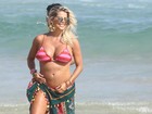 Karina Bacchi curte praia e mostra barriguinha da gravidez