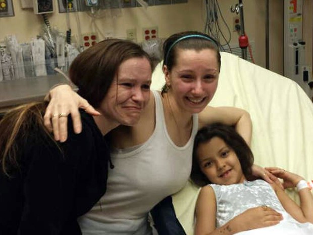 Amanda Berry (centro), com a irmã, (à esquerda), e a filha, que teve durante o cativeiro, posam em hospital após a libertação (Foto: AFP/Woio TV)