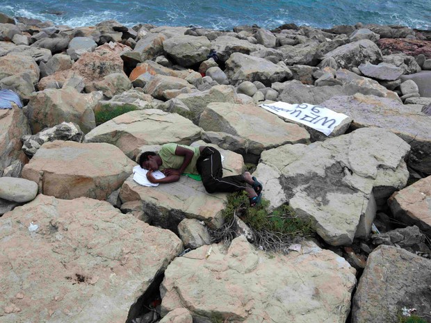 Um imigrante dorme sobre pedras em um paredão no Mar Mediterrâneo, na fronteira entre a França e a Itália. Nesta terça (16) a polícia começou a expulsar do local os cerca de 300 imigrantes, vindos principalmente da Eritreia e Sudão (Foto: Eric Gaillard/Reuters)