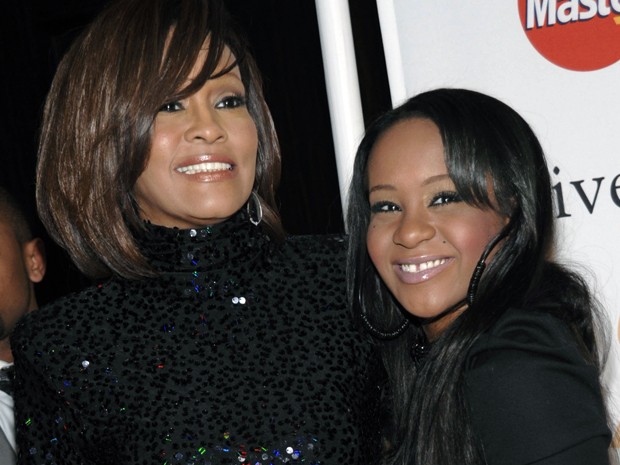 Bobbi Kristina Brown aparece ao lado de sua mãe, Whitney Houston, em foto de 12 de fevereiro de 2011 (Foto: AP Photo/Dan Steinberg, File)