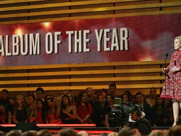 Adele, melhor performance solo pop, apresenta o troféu de melhor álbum do ano ao Mumford &amp; Sons. (Foto: Joe Klamar / AFPP Photo)
