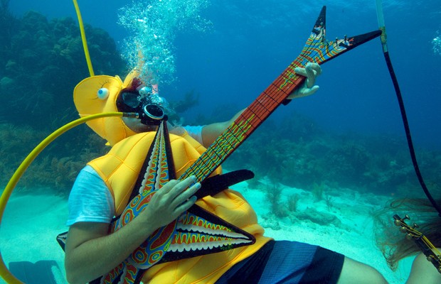 Jeff Wright se fantasiou de cavalo marinho e finge tocar uma guitarra durante o festival (Foto: Reuters)