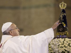 Papa toca a imagem de Nossa Senhora Aparecida que recebeu de presente (Foto: Felipe Dana/AP)