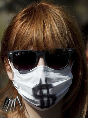 Ativista protesta contra o alto custo dos medicamentos em Santiago, no Chile, neste sábado (4) (Foto: AFP PHOTO/MARTIN BERNETTI )