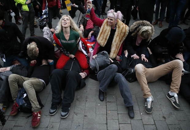 Grupo participa de sentada na cara coletiva em frente ao Parlamento britânico (Foto: Stefan Wermuth/Reuters)