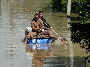 Homens usam barco improvisado em Srinagar (Foto: FP Photo/Punit Paranjpe)